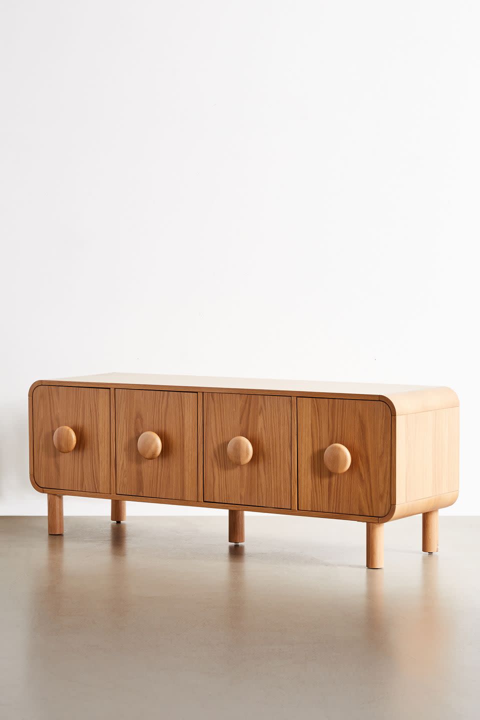 <p>Oversized round handles and chunky legs give this mid-century-inspired oak veneer media cabinet an up-to-date look and feel. Inside, shelves provide space to house those unsightly black boxes, wires and hubs. £449, <a href="https://www.urbanoutfitters.com/en-gb/?ref=logo" rel="nofollow noopener" target="_blank" data-ylk="slk:urbanoutfitters.com;elm:context_link;itc:0;sec:content-canvas" class="link ">urbanoutfitters.com</a></p>