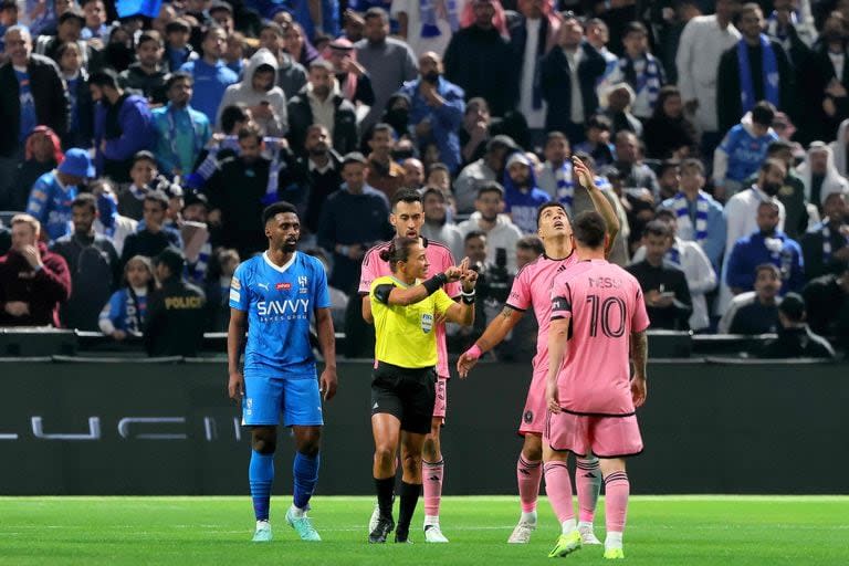 Luis Suárez le reclama a la jueza brasileña Edina Alves Batista ante la mirada de Lionel Messi