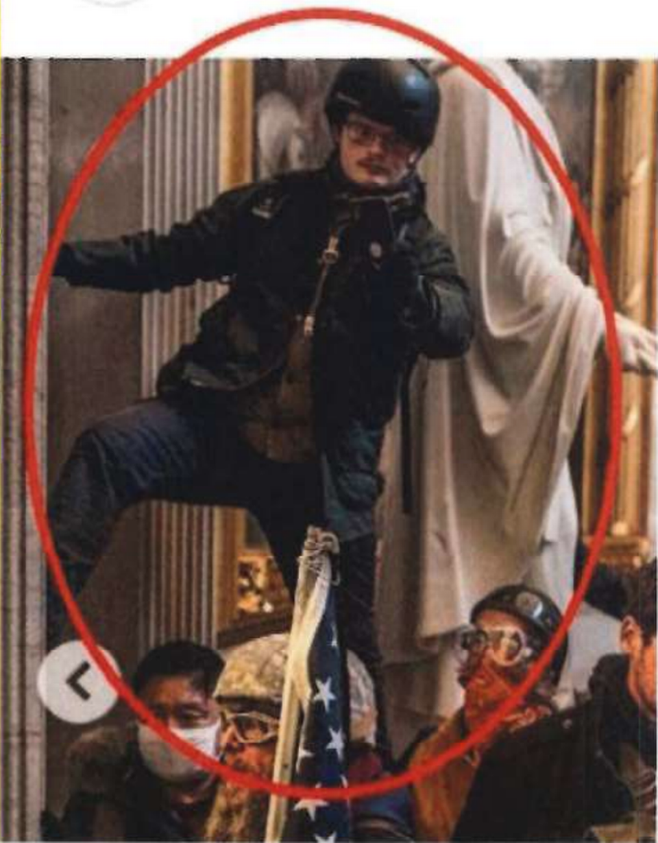 In this New York Times Magazine image taken from an FBI document, a man believed to be Stephen Ethan Horn of Wake Forest stands over other people with a cellphone in his left hand inside the U.S. Capitol on Jan. 6, 2021.