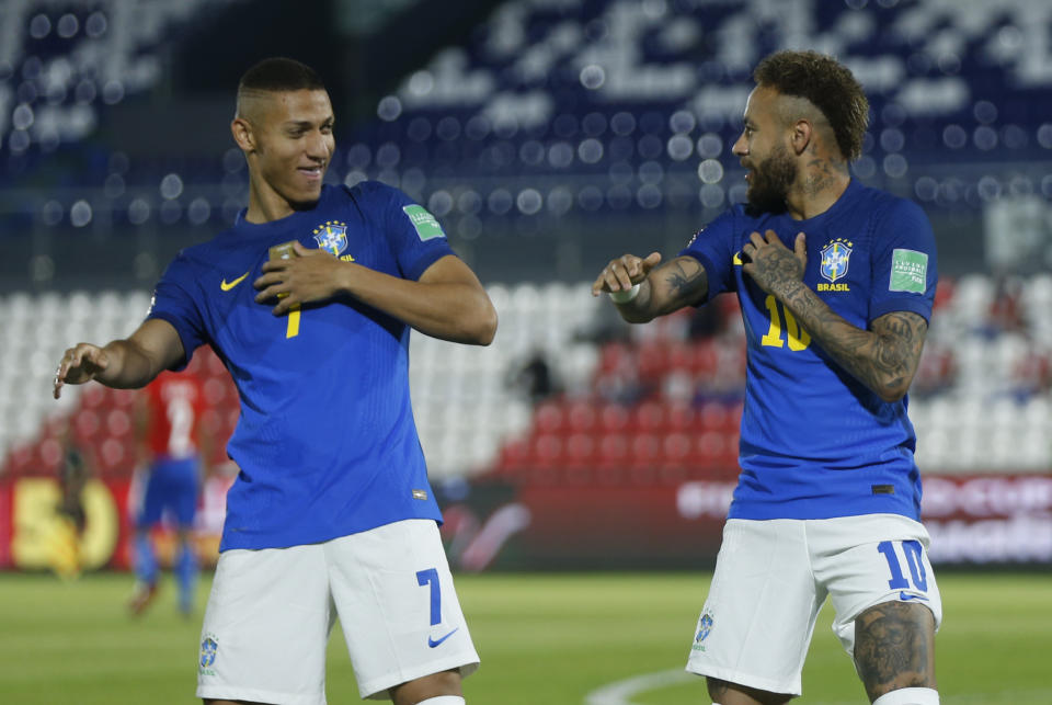 Neymar (derecha) celebra con su compañero Richarlison tras marcar el primer gol de Brasil en la victoria 2-0 ante Paraguay por las eliminatorias del Mundial, el martes 8 de junio de 2021, en Asunción. (AP Foto/Jorge Saenz)