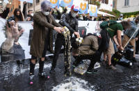 People spill beer on the ground during a protest against the government restriction measures to curb the spread of COVID-19, in Rome, Saturday, Oct. 24, 2020. Italian Premier Giuseppe Conte, who imposed severe-stay-at-home limits on citizens early on, then gradually eased travel and other restrictions, has been leaving it up to regional governors in this current surge of infections to order restrictions such as overnight curfews, including in places like Rome, Milan and Naples. (Mauro Scrobogna/LaPresse via AP)