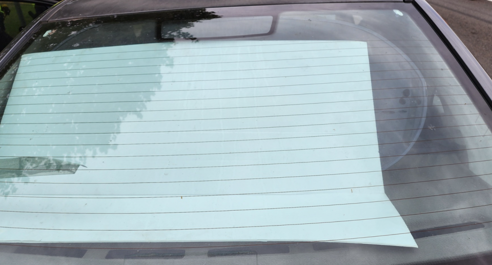 The car's back windshield pictured blocked with cardboard.