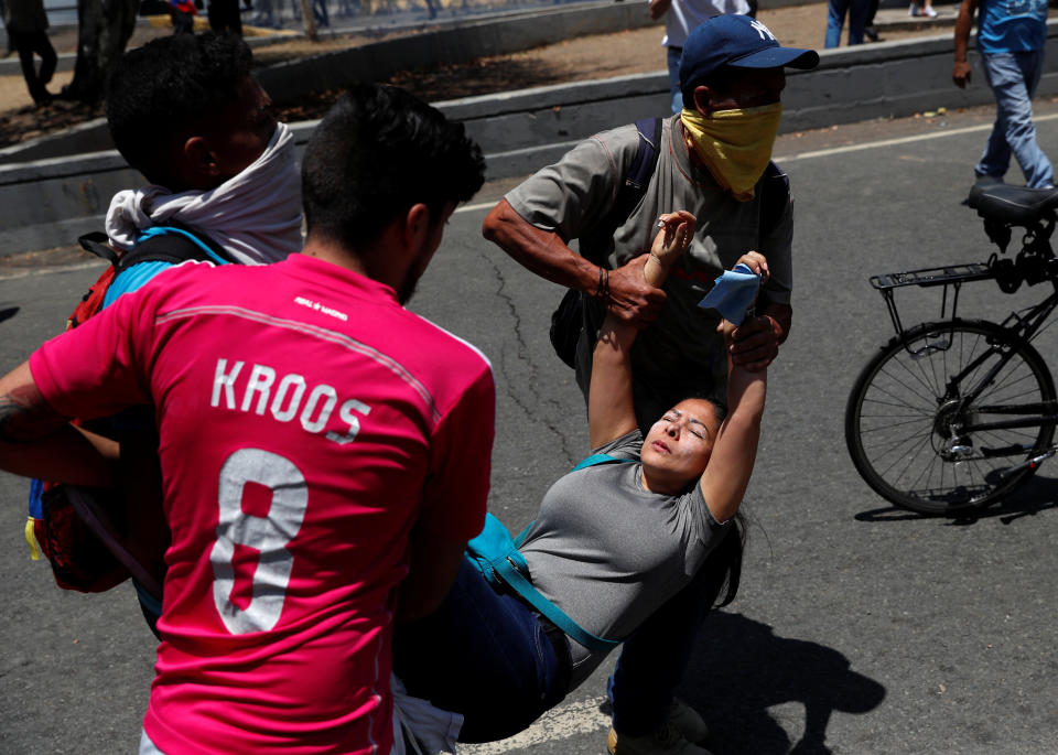 Opposition demonstrators help an injured fellow near the Generalisimo Francisco de Miranda Airbase "La Carlota" in Caracas, Venezuela April 30, 2019. (Photo: Carlos Garcia Rawlins/Reuters)