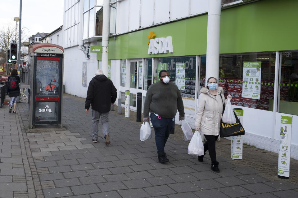 Local response to Coronavirus is felt on a street by street level as people wearing face masks carry their shopping bags outside Asda supermarket on Kings Heath High Street on 6th April 2020 in Birmingham, England, United Kingdom. Coronavirus or Covid-19 is a new respiratory illness that has not previously been seen in humans. While much or Europe has been placed into lockdown, the UK government has announced more stringent rules as part of their long term strategy, and in particular 'social distancing'. (photo by Mike Kemp/In PIctures via Getty Images)