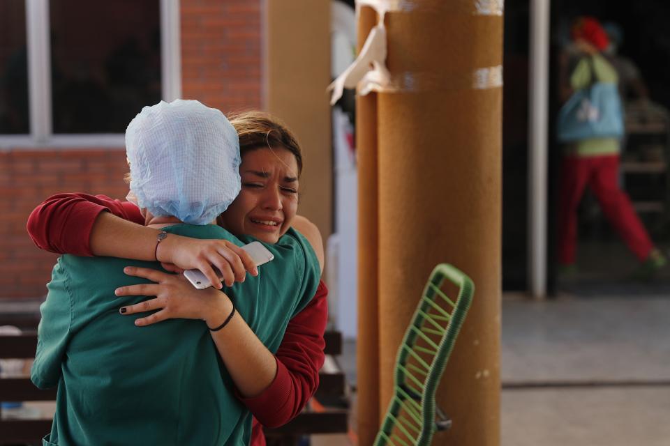 Laura Aguero, the niece of 38-year-old lawyer Arturo Benitez who spent 25 days in the ICU for COVID-19 at Clinicas Hospital, embraces a nurse after learning he died, in San Lorenzo, Paraguay, Friday, June 4, 2021. Aguero said the family spent almost $15,000 dollars on medication for him that was not provided by the hospital. (AP Photo/Jorge Saenz)