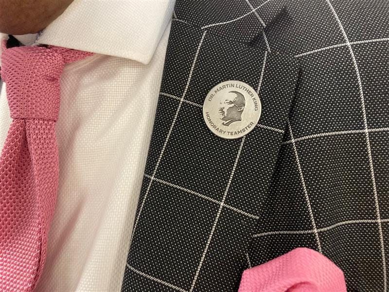 The pin honoring the induction of Martin Luther King Jr. as an honorary member of the International Brotherhood of Teamsters being worn by Anthony Rosa.