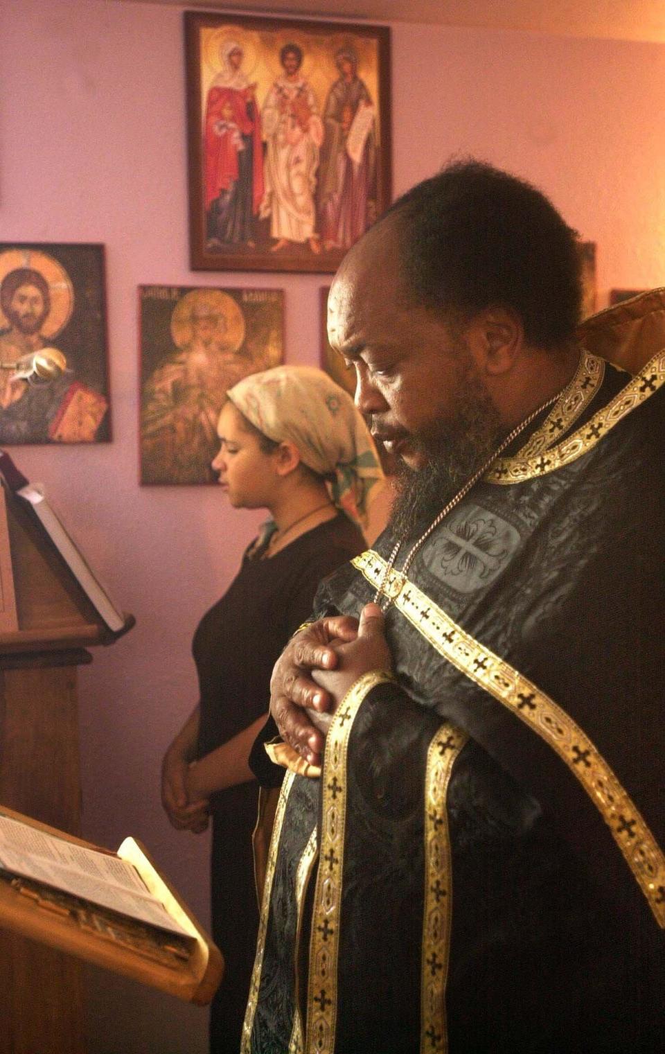 Father Moses Berry, right, performed three services Friday during the National Day of Prayer at the Unexpected Joy Orthodox Christian Mission in Ash Grove. His daughter, Dorothy Berry, 12, reads in response.