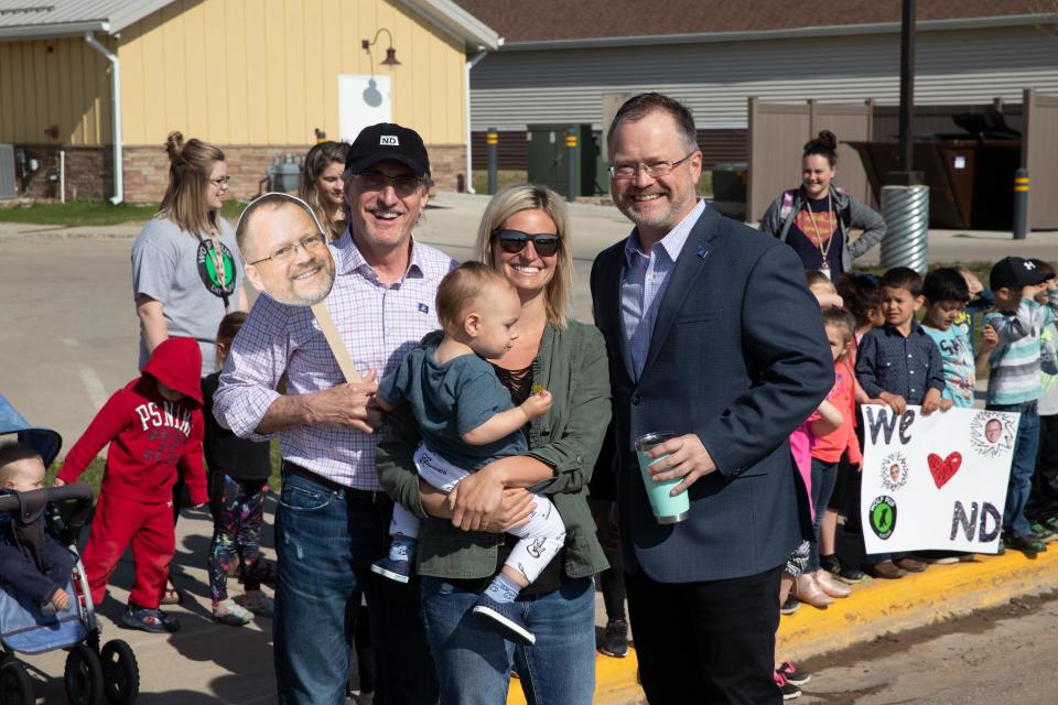 Tessa Moberg, in glasses, runs Wolf Pup Daycare in North Dakota, where there is as yet no state-wide shelter in place order. This photo was taken before the coronavirus struck, and features on the left Gov. Doug Burgum and on the right Lt. Gov. Brent Sanford.