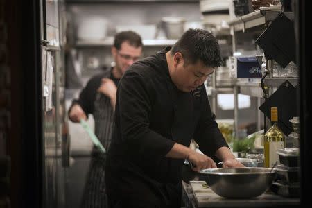 A cook is seen working in the kitchen at restaurant Marc Forgione in New York April 3, 2014. REUTERS/Brendan McDermid