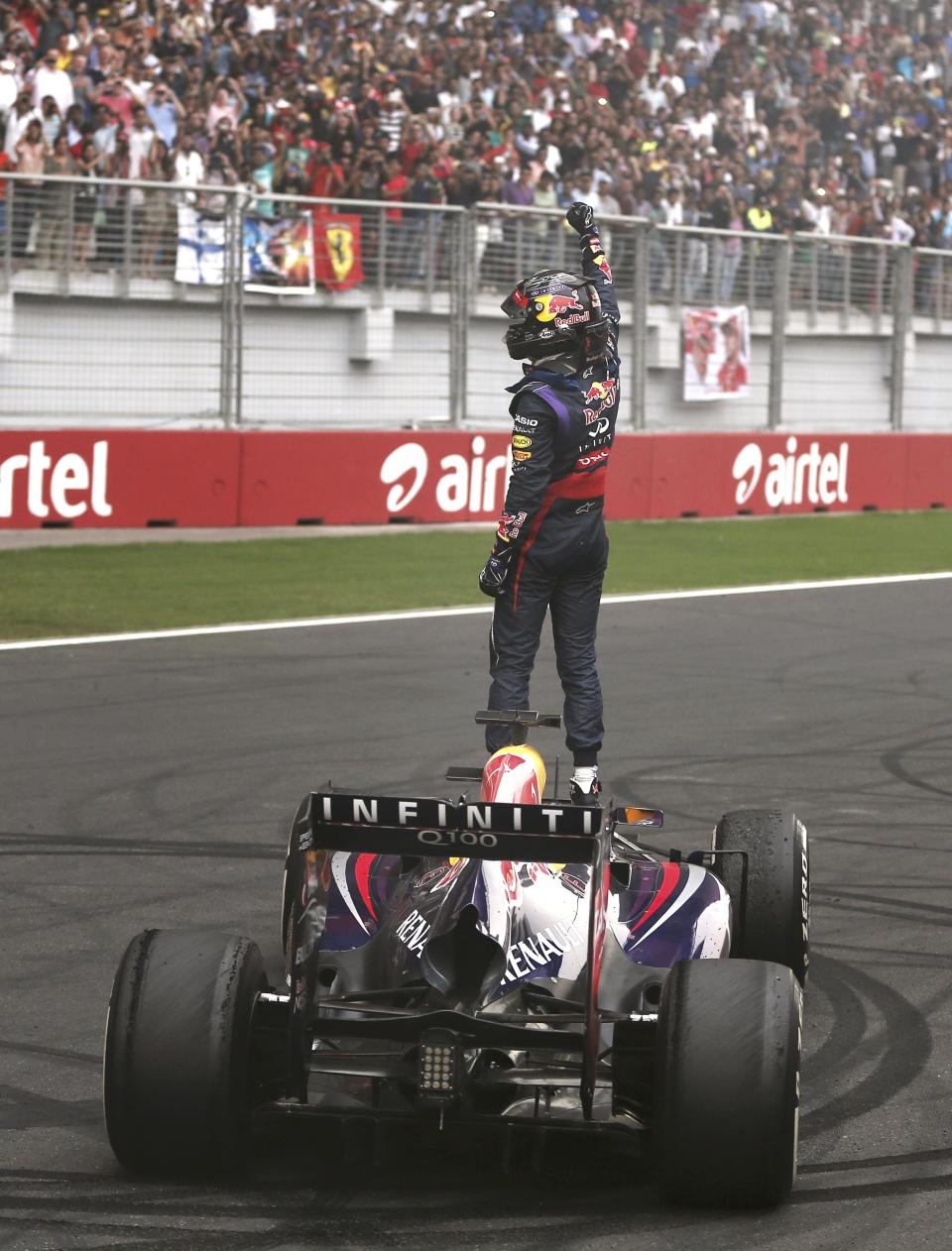 Red Bull Formula One driver Vettel celebrates atop his car after winning the Indian F1 Grand Prix at the Buddh International Circuit in Greater Noida