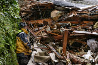 Southern Marin Fire Department members search a crushed house in the aftermath of a mudslide that destroyed three homes on a hillside in Sausalito, Calif., Thursday, Feb. 14, 2019. Waves of heavy rain pounded California on Thursday, filling normally dry creeks and rivers with muddy torrents, flooding roadways and forcing residents to flee their homes in communities scorched by wildfires. (AP Photo/Michael Short)