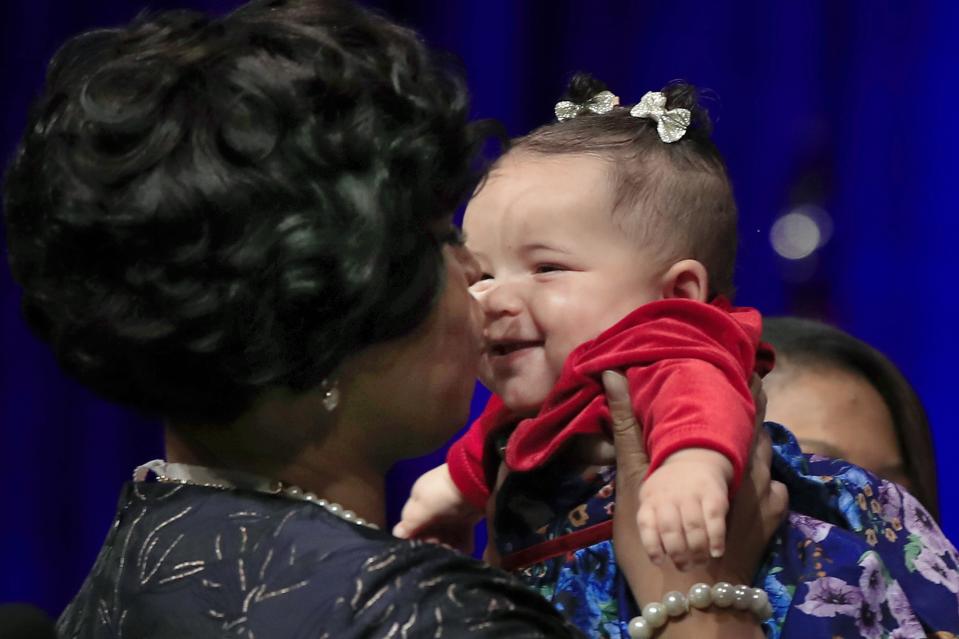 FILE - In this Jan. 2, 2019 file photo, District of Columbia Mayor Muriel Bowser kisses her daughter Miranda Elizabeth Bowser, after being sworn in as mayor of the District of Columbia. It's not unheard of for politicians to sometimes bring their children to work. Providence, R.I., Mayor Jorge Elorza occasionally brings his son Omar to events. New Zealand Prime Minister Jacinda Ardern attended a meeting of the United Nations General Assembly in 2018 with her infant daughter, Neve. (AP Photo/Manuel Balce Ceneta, File)