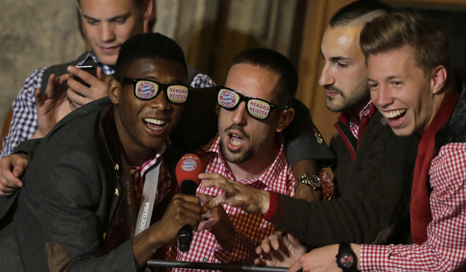 Bayern's David Alaba of Austria, from left, Franck Ribery of France, Diego Contento and Mitchell Weiser celebrate on the town hall balcony after winning the German Soccer Championship after the season's last home game between FC Bayern Munich and VfB Stuttgart, in Munich, southern Germany, Saturday, May 10, 2014. (AP Photo/Matthias Schrader)