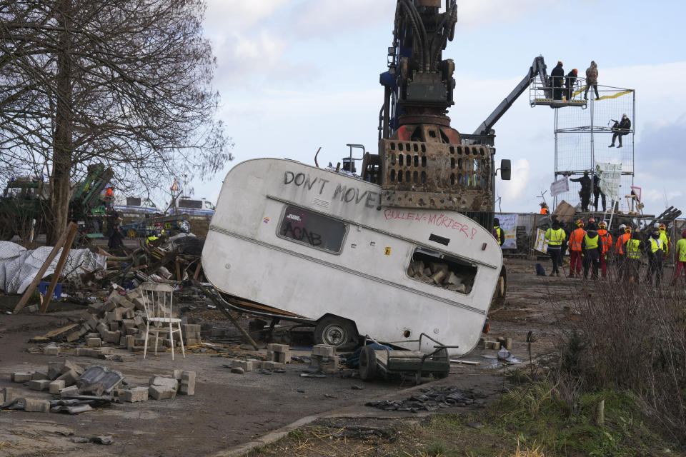 A caravan is taken from a road at the village Luetzerath, near Erkelenz, Germany, Wednesday, Jan. 11, 2023. Police have entered the condemned village in, launching an effort to evict activists holed up at the site in an effort to prevent its demolition to make way for the expansion of a coal mine. (AP Photo/Michael Probst)