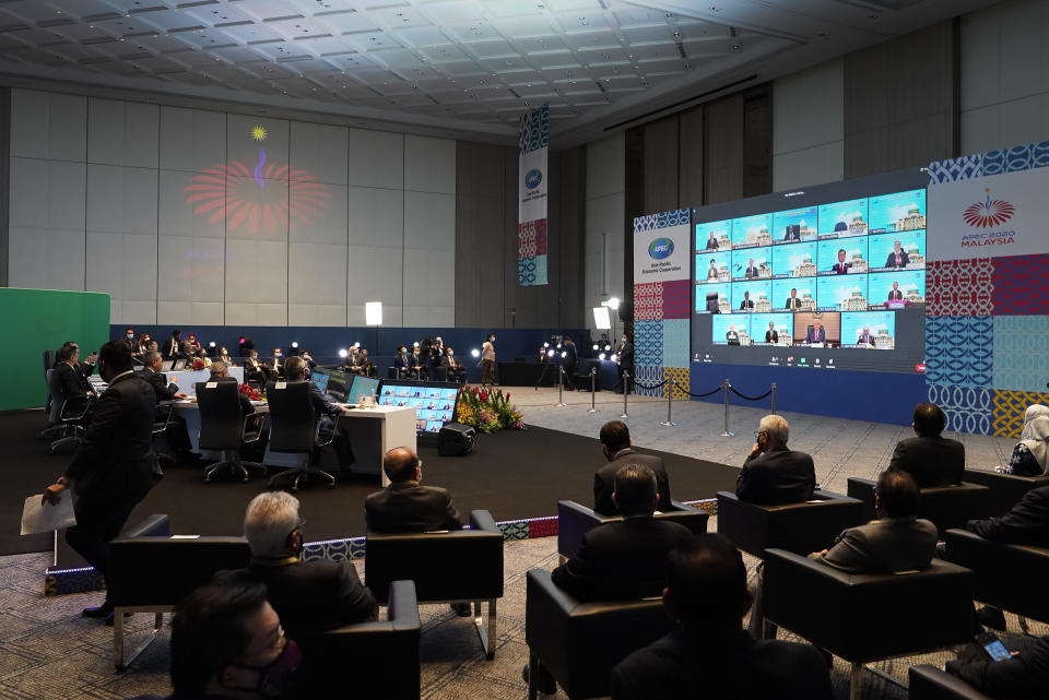 Malaysia's Prime Minister Muhyiddin Yassin, table at left, attend the opening remarks of the first virtual Asia-Pacific Economic Cooperation (APEC) leaders' summit, hosted by Malaysia, in Kuala Lumpur, Malaysia, Friday, Nov. 20, 2020. (AP Photo/Vincent Thian)