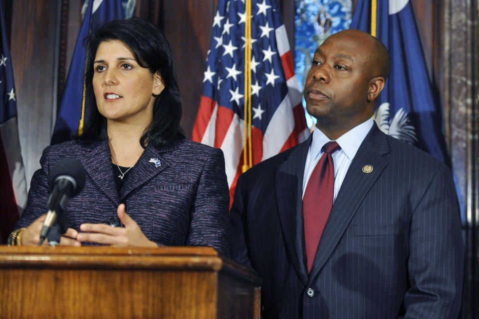FILE - South Carolina Gov. Nikki Haley, left, speaks at a news conference as she announces Rep Tim Scott, center, as the state's next U.S. Senator at the South Carolina Statehouse on Dec. 17, 2012, in Columbia, S.C. Haley and Scott are forever linked by that announcement, cementing their status as rising stars in a Republican Party frustrated by Barack Obama's reelection just a month earlier. But nearly a dozen years later, they find themselves poised to run against each other for the GOP presidential nomination. Haley has already launched a campaign, and Scott took steps last week toward initiating a bid of his own.(AP Photo/Rainier Ehrhardt, File)