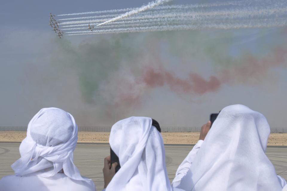 Emirati men film a show by the Italian air force's Frecce Tricolori at the Dubai Air Show in Dubai, United Arab Emirates, Wednesday, Nov. 15, 2023. (AP Photo/Jon Gambrell)