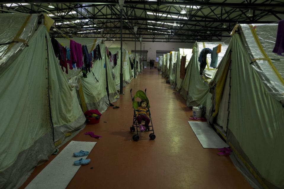 In this Thursday, Jan. 19, 2017 photo, a Syrian refugee child sits in a stroller outside his family's tent in Kalochori refugee camp on the outskirts of the northern Greek city of Thessaloniki. (AP Photo/Muhammed Muheisen)