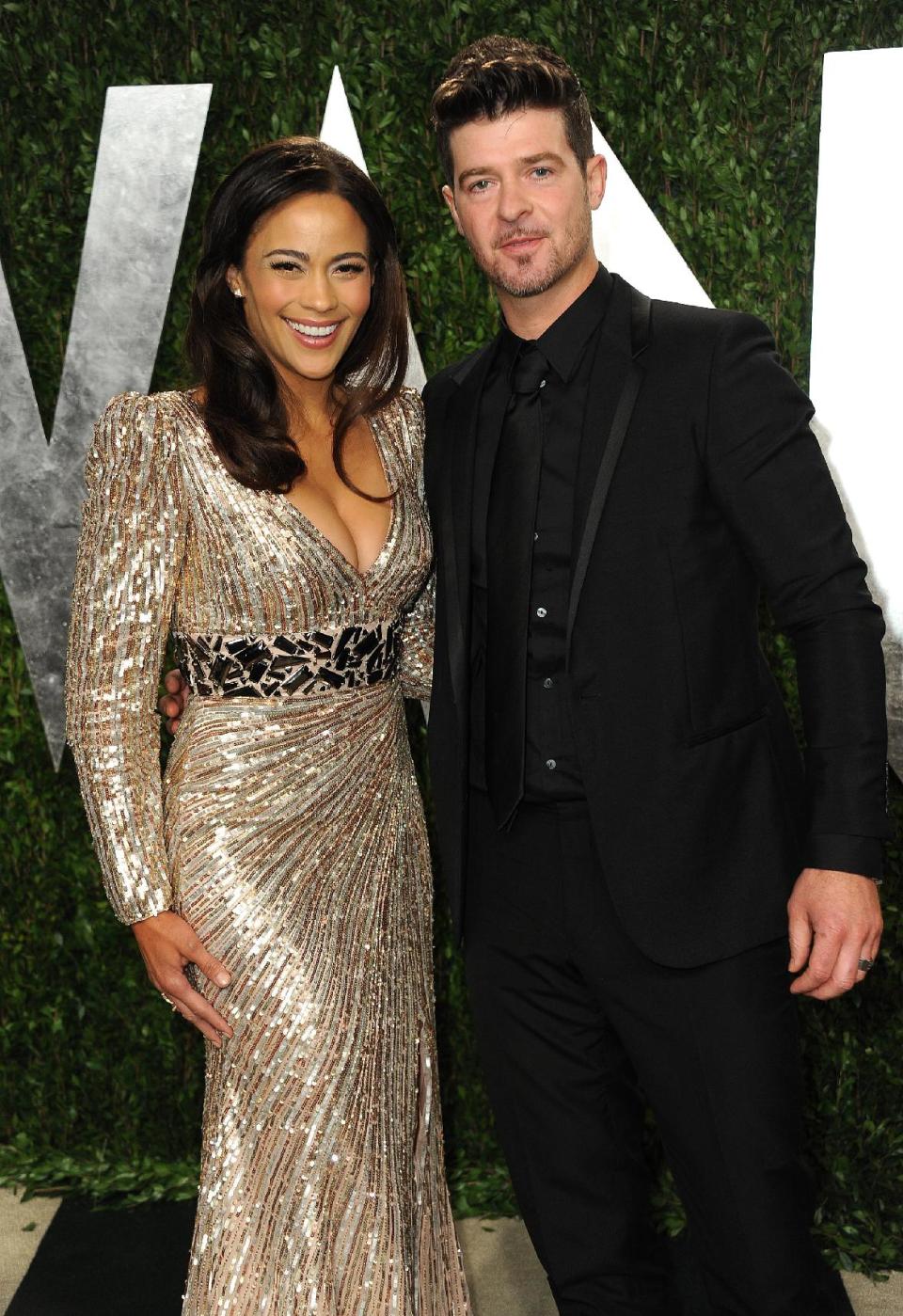 FILE - In this Feb. 24, 2013 file photo, Paula Patton and Robin Thicke arrive at the 2013 Vanity Fair Oscars Viewing and After Party at the Sunset Plaza Hotel in West Hollywood, Calif. Thicke originally didn't plan to release the unrated version of his music video for the song “Blurred Lines,” which features nude models prowling around him and rappers Pharrell and T.I. Thicke said his wife was OK with the models on the set and he sought her approval: “Obviously if she didn't like it I wouldn't put it out.” (Photo by Jordan Strauss/Invision/AP, File)