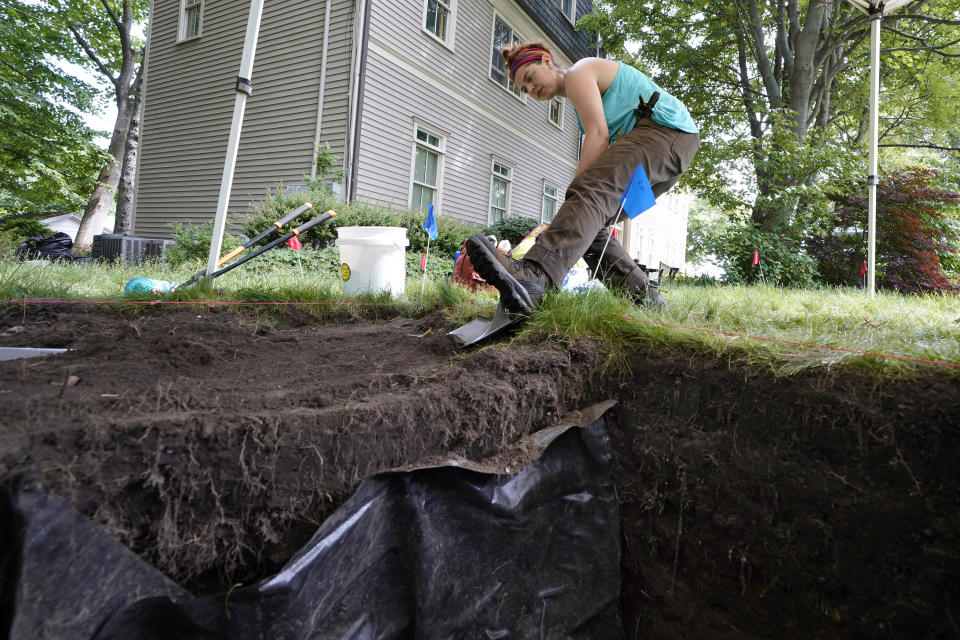 University of Massachusetts Boston graduate student Claire Norton, of Boston, uses a shovel to remove layers of soil while working to uncover artifacts at an excavation site, Wednesday, June 9, 2021, on Cole's Hill, in Plymouth, Mass. Norton is part of a team of archaeologists excavating the grassy hilltop that overlooks iconic Plymouth Rock one last time before a historical park is built on the site. (AP Photo/Steven Senne)