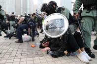La policía arresta a un manifestante después de que una bandera china fuera retirada del asta de una bandera en un acto de apoyo a los derechos humanos de los uigures de Xinjiang en Hong Kong
