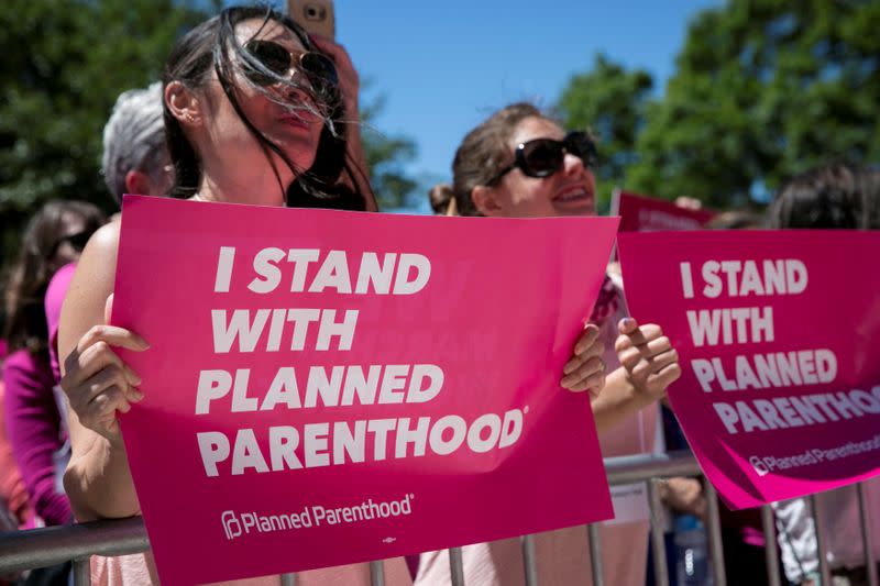 FILE PHOTO: Demonstrators hold placards during a Planned Parenthood rally outside the State Capitol in Austin