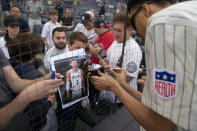 Victor Wembanyama, a projected first round 2023 NBA draft prospect, signs autographs before throwing the ceremonial first pitch before a baseball game between the New York Yankees and the Seattle Mariners, Tuesday, June 20, 2023, in New York. (AP Photo/John Minchillo)