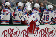 FILE - In this March 10, 2020, file photo, advertising is shown on the boards as New York Rangers center Mika Zibanejad (93) gets congratulated by the bench after scoring a goal against the New York Rangers during the first period of an NHL hockey game in Dallas. While the coronavirus pandemic circles the world, sports business executives are having conversations about lucrative advertising and marketing contracts with no games on the horizon. (AP Photo/Michael Ainsworth, File)