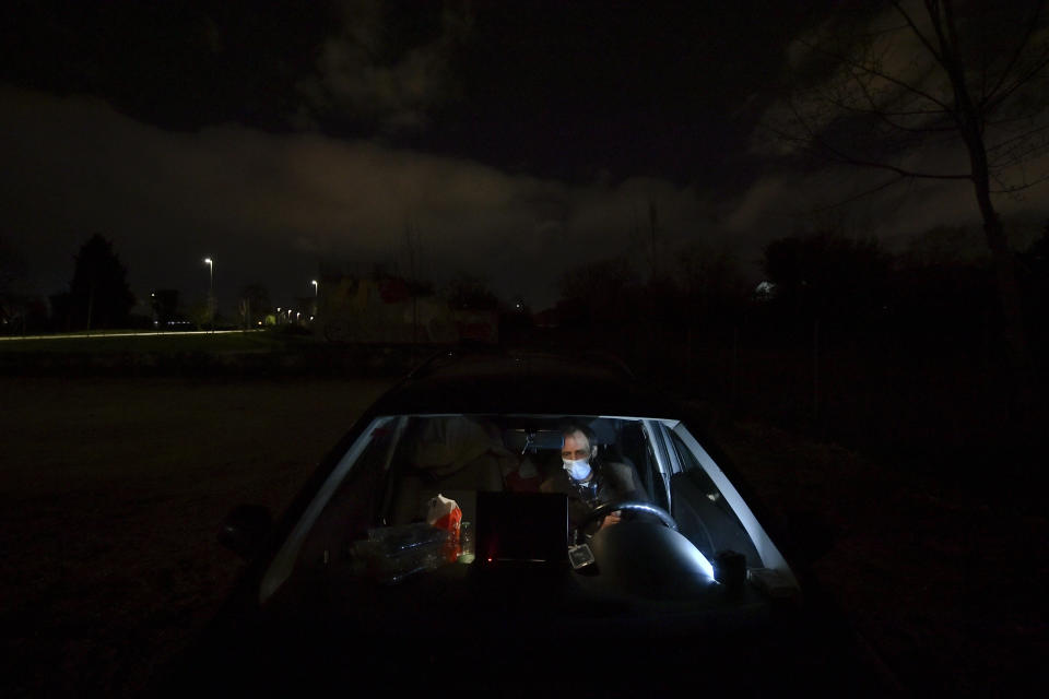 Juan Jimenez, 60, sits in his car which is now his home in Pamplona, northern Spain, Tuesday, March 17, 2021. The 620 euros Jimenez has received in government aid in recent months went to his seven children. "We are invisible beings," Jimenez said from his car that is cluttered with clothes, blankets, and bags stuffed with all that he owns. (AP Photo/Alvaro Barrientos)