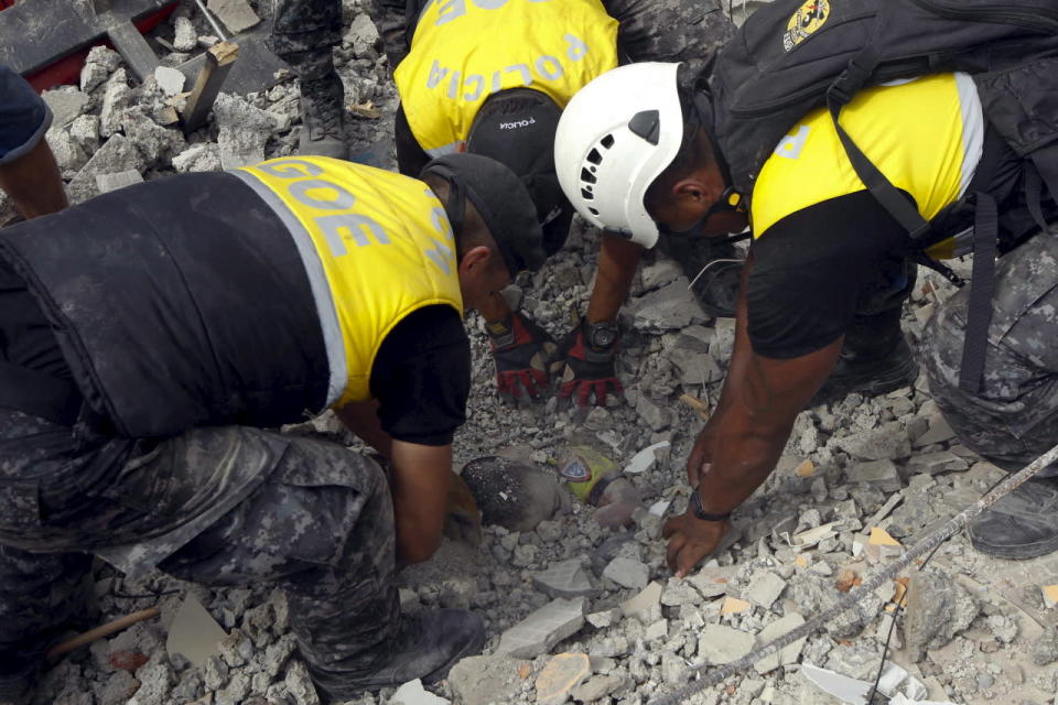 Police officers uncover the body of a victim