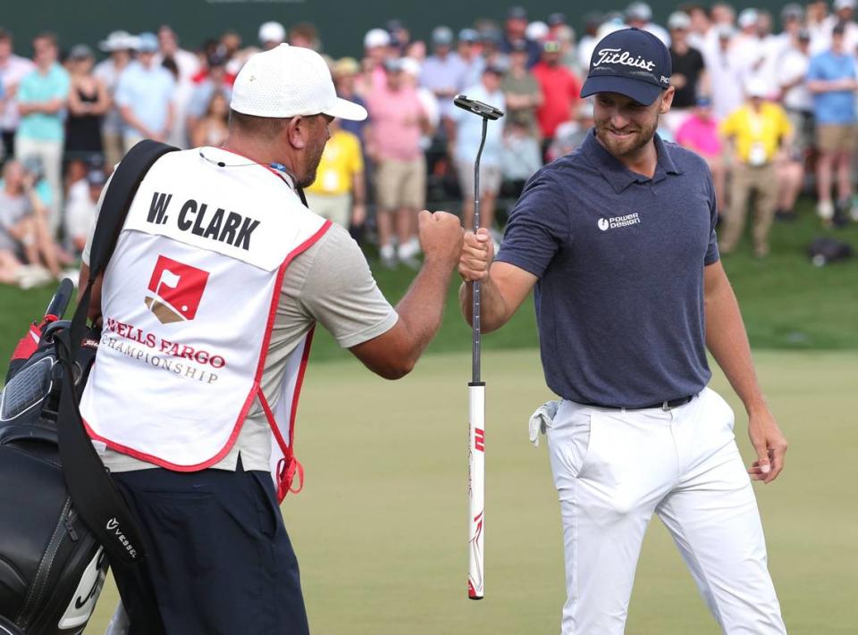Wyndham Clark, right, bumps fist with his caddie, left, after sinking the winning putt at the Wells Fargo Championship at Quail Hollow Club in Charlotte, NC on Sunday, May 7, 2023. Clark shot -19 for the tournament.