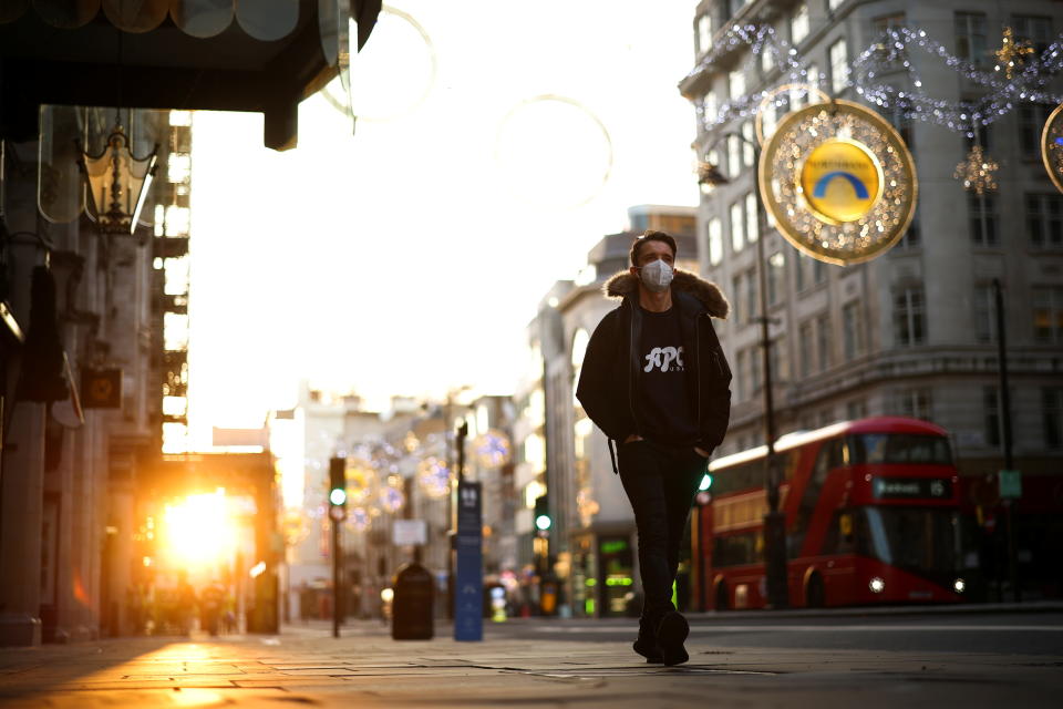 A man wearing a protective face mask walks down Strand during sunset, amid the coronavirus disease (COVID-19) outbreak, in London, Britain, November 5, 2020. REUTERS/Henry Nicholls