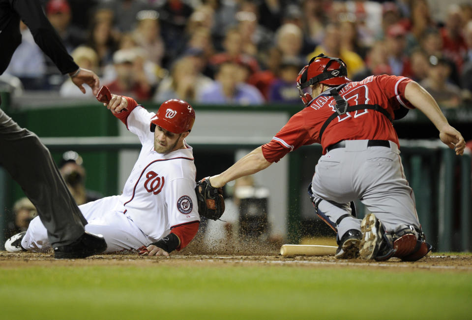 Washington Nationals' Bryce Harper, left, is tagged out at home by Los Angeles Angels catcher Chris Iannetta, right, during the fourth inning of a baseball game, Monday, April 21, 2014, in Washington. (AP Photo/Nick Wass)