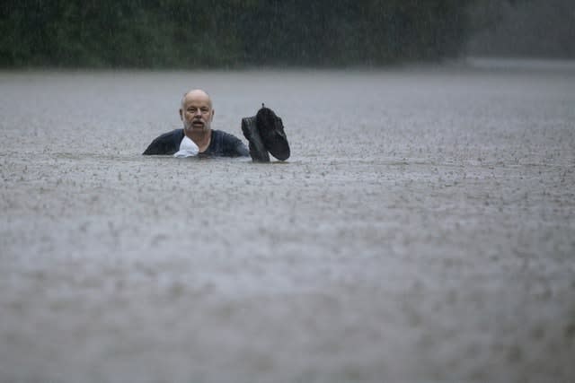 A man wades through floodwater in Patton Village