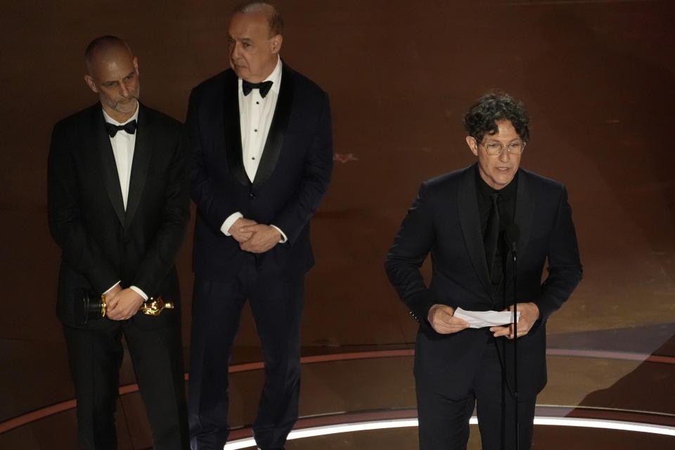 James Wilson (izquierda), Leonard Blavatnik (centro) y Jonathan Glazer aceptan el Oscar a mejor largometraje internacional por "The Zone of Interest" ("Zona de interés") durante la entrega de los premios el domingo 10 de marzo de 2024, en el Teatro Dolby de Los Ángeles. (AP Foto/Chris Pizzello)