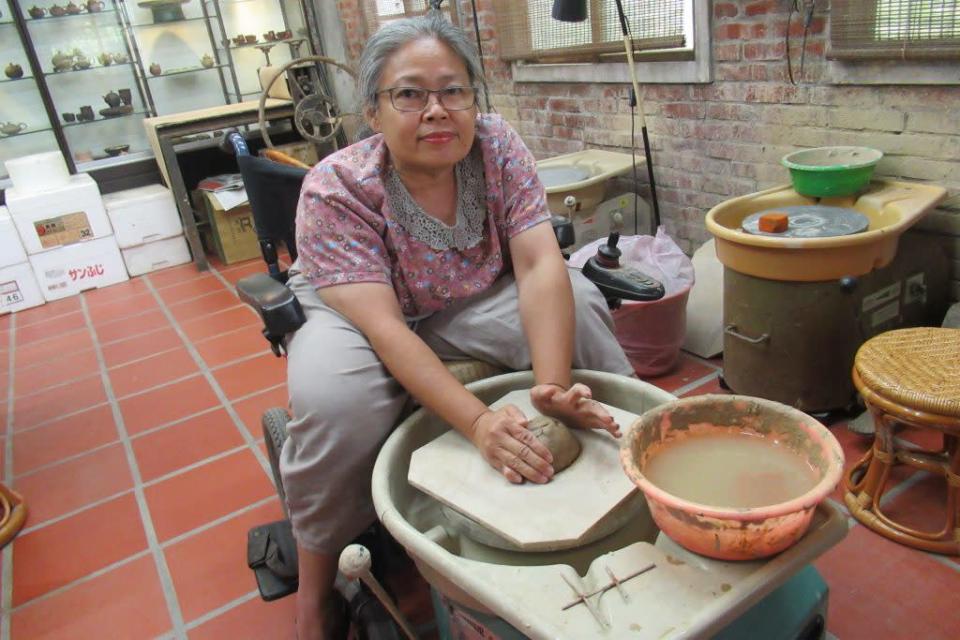 周美智坐在輪椅上從事陶藝創作，並不輕鬆。