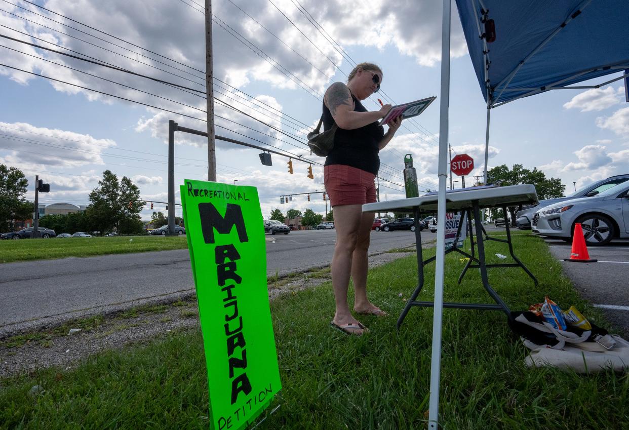 Jul 31, 2023; Columbus, OH, US; Julie Porr signs a petition to approve Recreational Marijuana in Ohio in front of the Franklin County Board of Elections. The table hosting the petitions was under an awning that was also providing "Vote No on Issue One" signs.