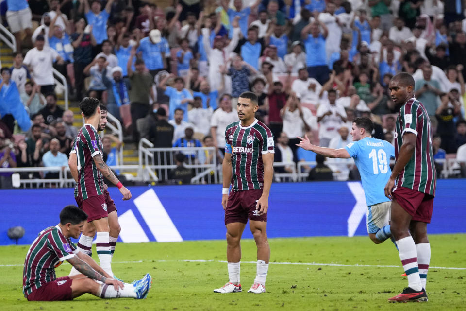 Fluminense players react as Manchester City's Julian Alvarez, background right, celebrates after scoring his side's fourth goal during the Soccer Club World Cup final match between Manchester City FC and Fluminense FC at King Abdullah Sports City Stadium in Jeddah, Saudi Arabia, Friday, Dec. 22, 2023. (AP Photo/Manu Fernandez)