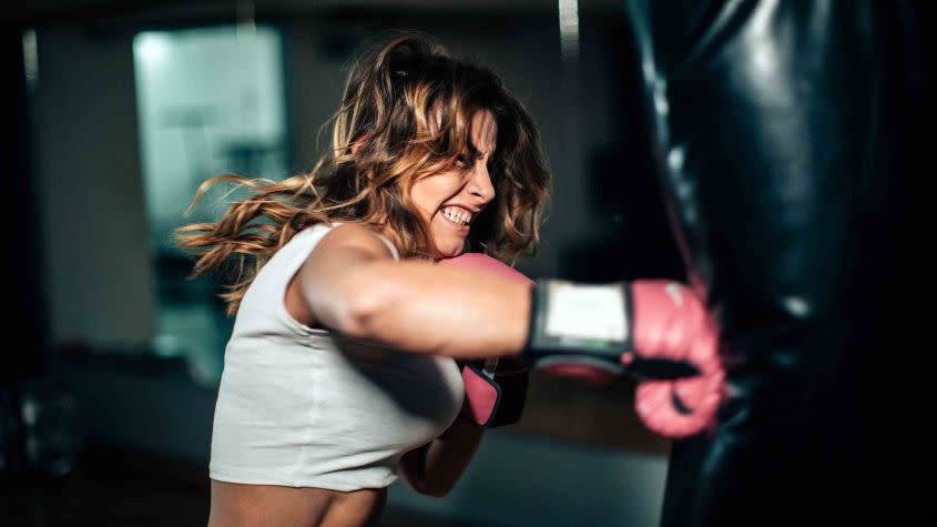 A female boxer punches a punching bag