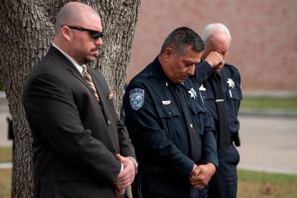 Members of the Bay St. Louis Police Department bow their heads as a prayer is said during a ceremony dedicating commemorative stars in honor of Sergeant Steven Robin and Officer Branden Estorffe outside the new Bay St. Louis Police Department in Bay St. Louis on Thursday, Dec. 14, 2023.