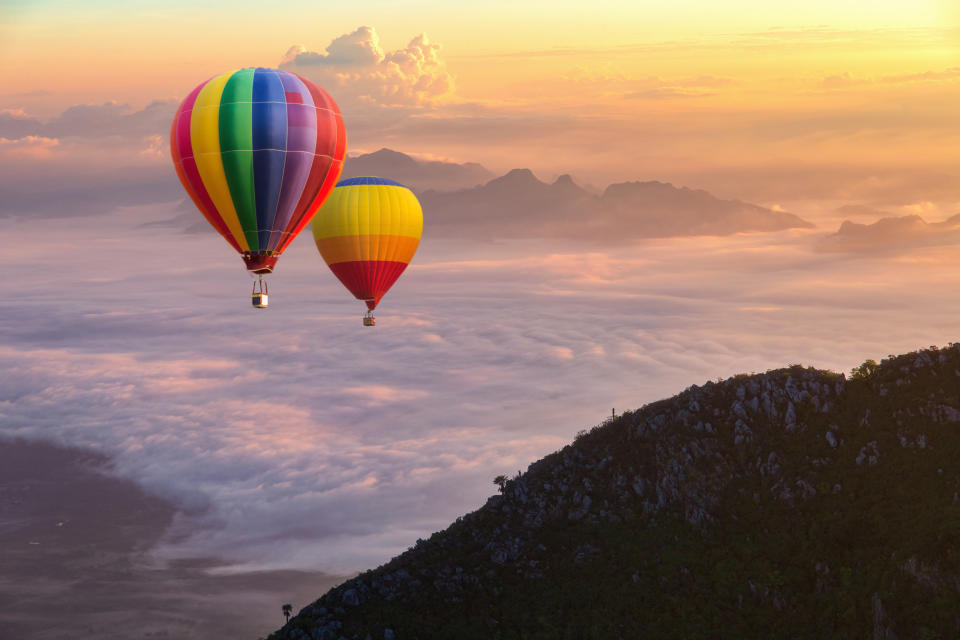 Colorful hot-air balloons flying over the Doi Luang Chiang Dao with sunrise and morning mist at Chiang mai, Thailand.