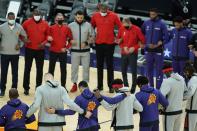 Members of the Phoenix Suns and the Toronto Raptors form a circle during the American national anthem prior to an NBA basketball game Wednesday, Jan. 6, 2021, in Phoenix. (AP Photo/Ross D. Franklin)