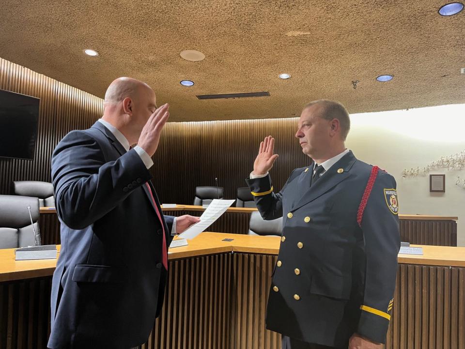 Mansfield fire Lt. Matthew Emerson was promoted to captain Wednesday. Here, Safety-Service Director Keith Porch administers the oath of office.