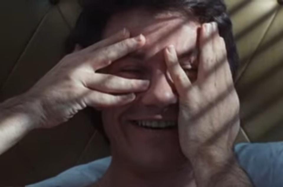 Harvey Keitel covers his eyes and smiles