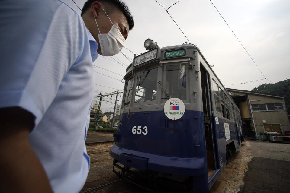 A tram which survived the Hiroshima atomic bombing is seen at a train maintenance facility of Hiroshima Electric Railway in Hiroshima, western Japan Monday, Aug. 3, 2020. It has been restored and repainted its original colors, will run on the street on Aug. 6 to commemorate the day of the U.S. first atomic bombing in the city. (AP Photo/Eugene Hoshiko)