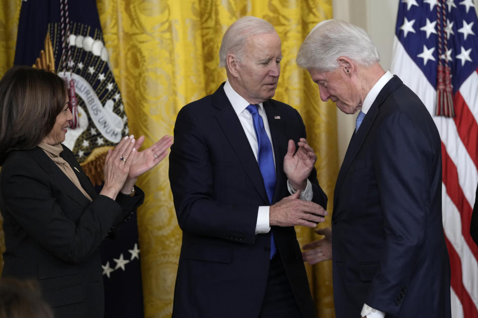 President Joe Biden shakes hands with former President Bill Clinton as Vice President Kamala Harris applauds during an event in the East Room of the White House in Washington, Thursday, Feb. 2, 2023, to mark the 30thAnniversary of the Family and Medical Leave Act. (AP Photo/Susan Walsh)