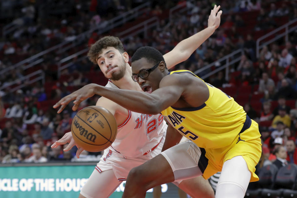 Indiana Pacers forward Jarace Walker, right, has the ball knocked away by Houston Rockets center Alperen Sengun during the first half of an NBA basketball game Tuesday, Dec. 26, 2023, in Houston. (AP Photo/Michael Wyke)