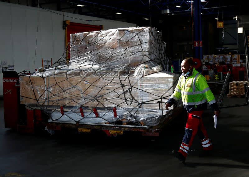 A worker preprares to load medical supplies in a cargo aircraft at Liege airport