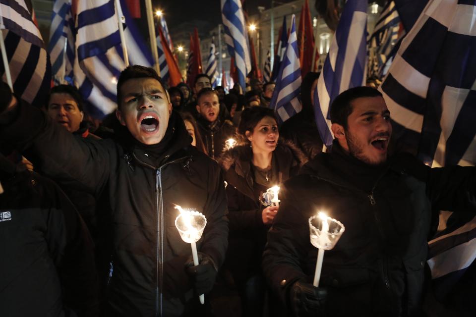 Supporters of Greece's extreme right party Golden Dawn sing the national anthem during a rally in Athens on Saturday, Feb.1, 2014. About 3,000 people took part in the rally to commemorate a 1996 incident which cost the lives of three navy officers and brought Greece and Turkey to the brink of war. A number of leftist groups held two separate counter-rallies a short distance away, but police forbade the groups from marching and meeting each other to prevent violent incidents. Six lawmakers of the party, including the Golden Dawn's leader Nikolaos Michaloliakos, are in jail on charges of being prominent members of a criminal organization. (AP Photo/Yannis Kolesidis)