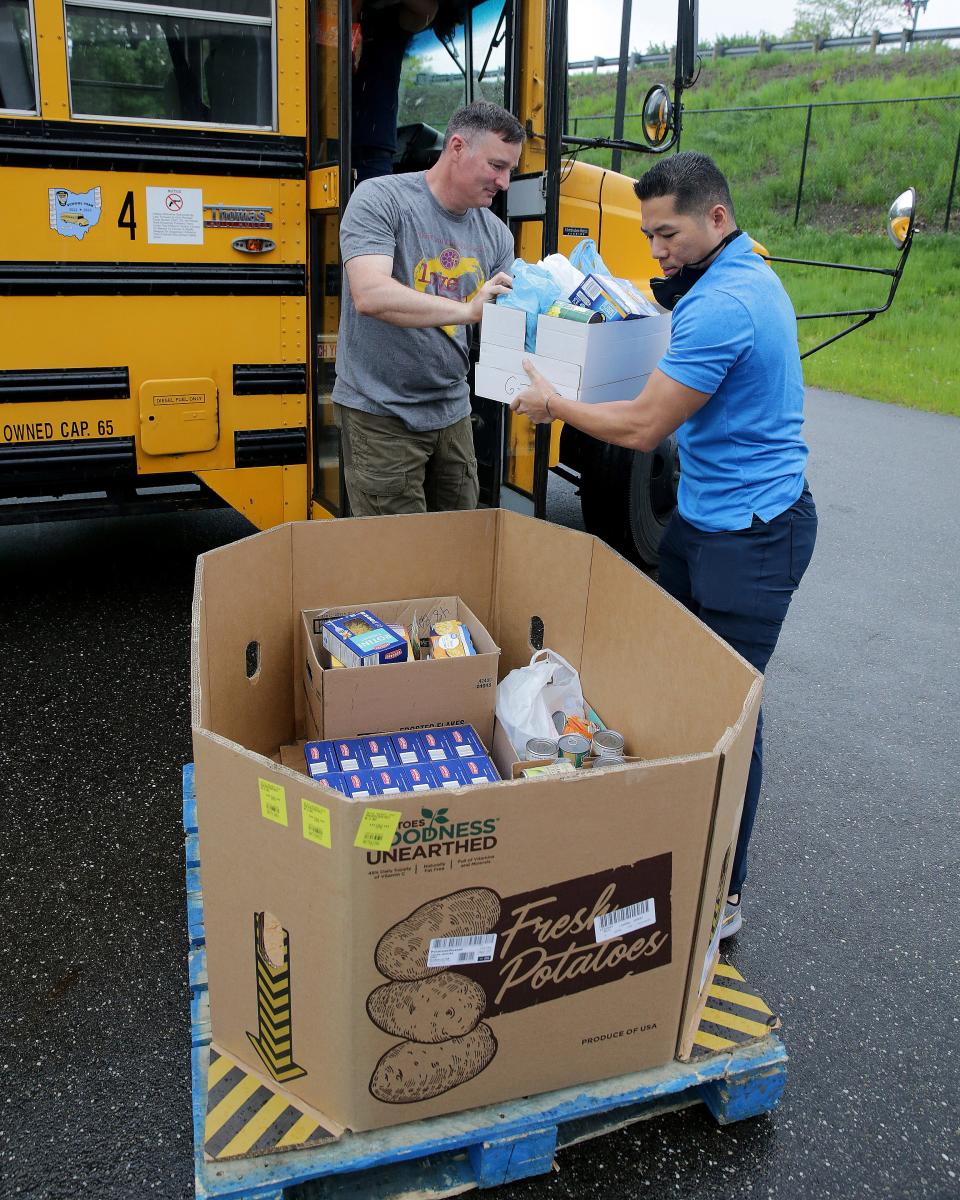 Brian O'Donnell, left, a volunteer from FirstEnergy, and Nicholas Jones from Surgere, unload a bus full of food from a Dalton Local bus.